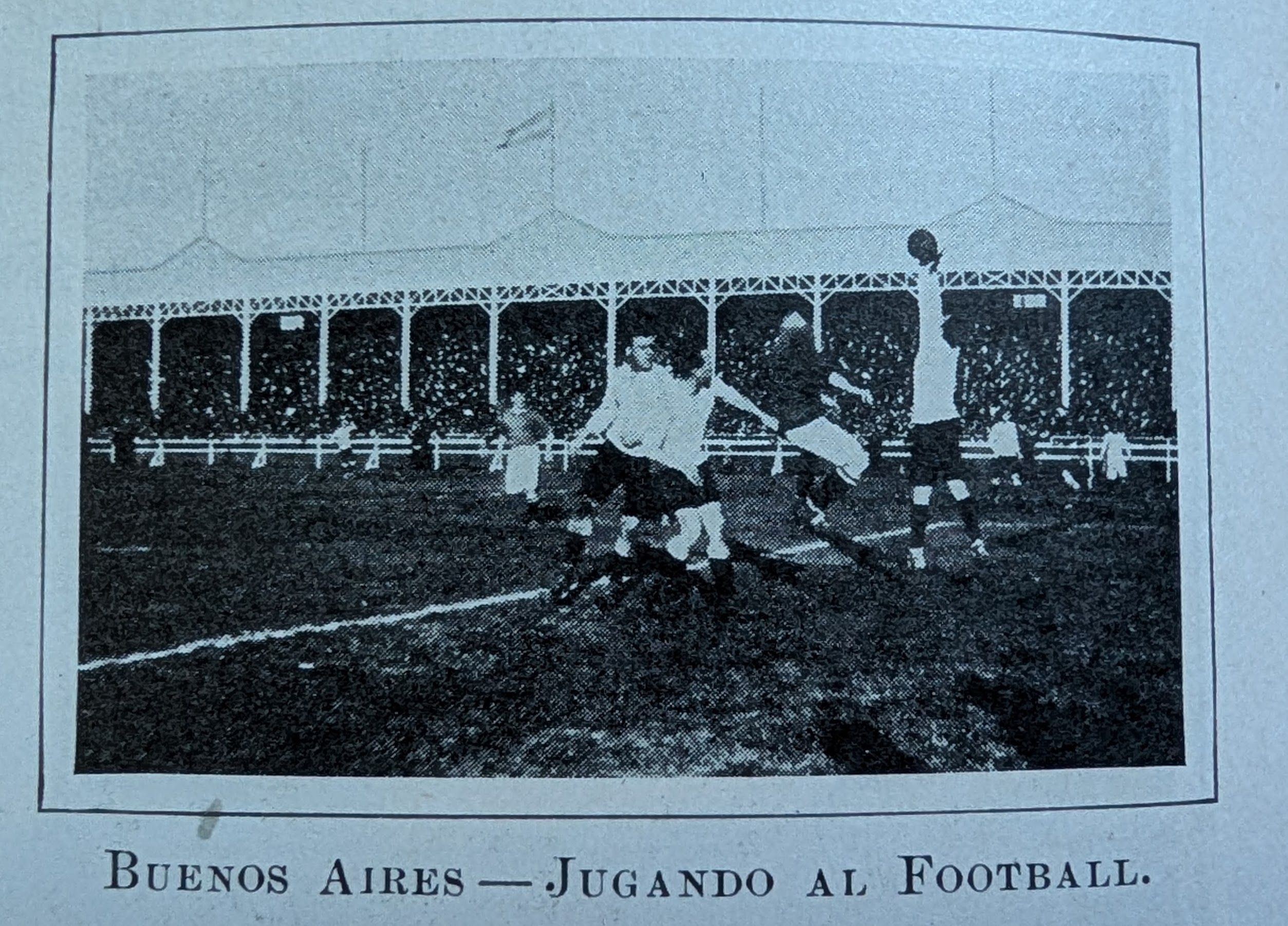 Antique photo of men playing soccer. The caption, in Spanish, reads, Buenos Aires, playing soccer.